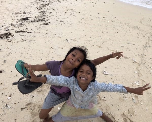 children smiling on beach in fiji remote island