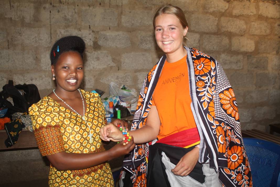 Tanzanian teacher giving gift to volunteer