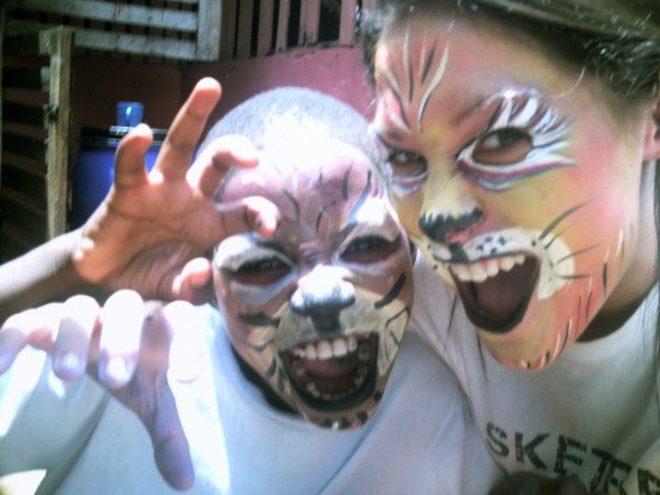 volunteer and child with face paint