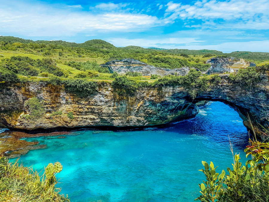 blue water under natural bridge in Bali