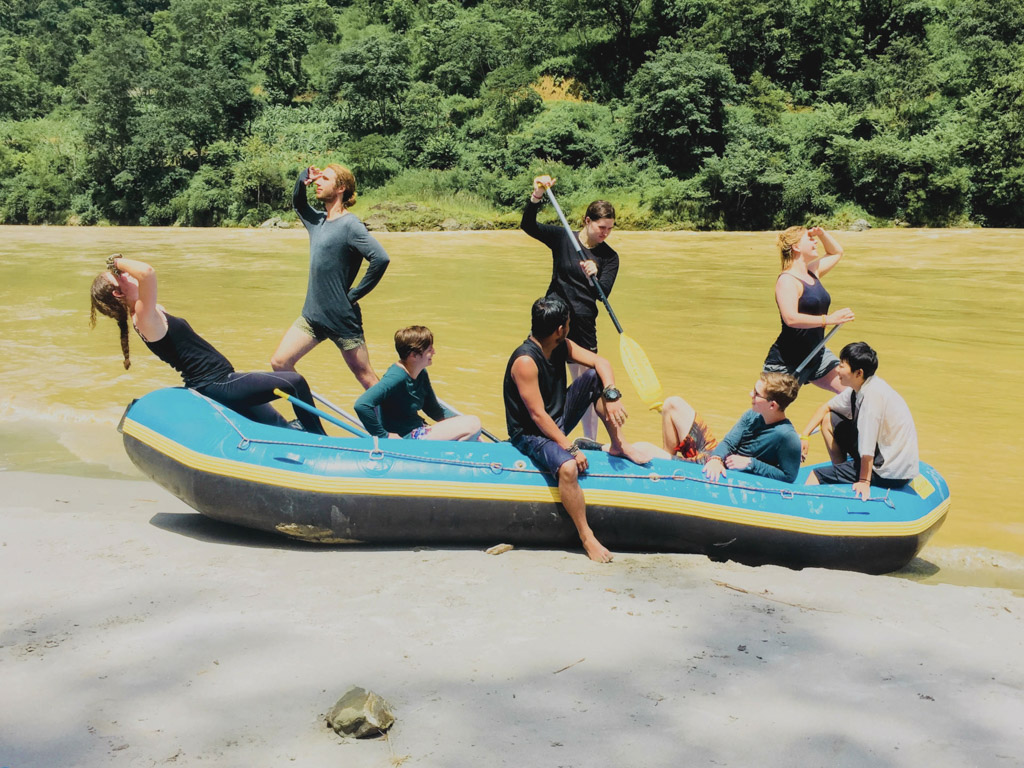 group in inflatable boat by river