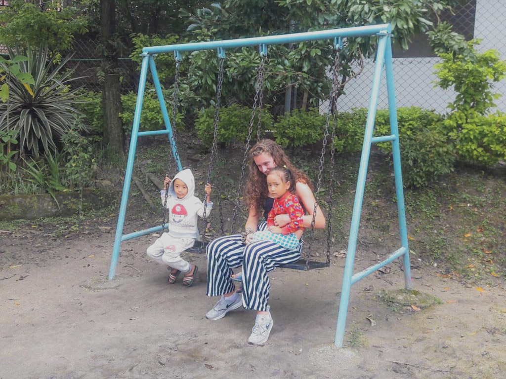 playing on swings with Nepalese kids