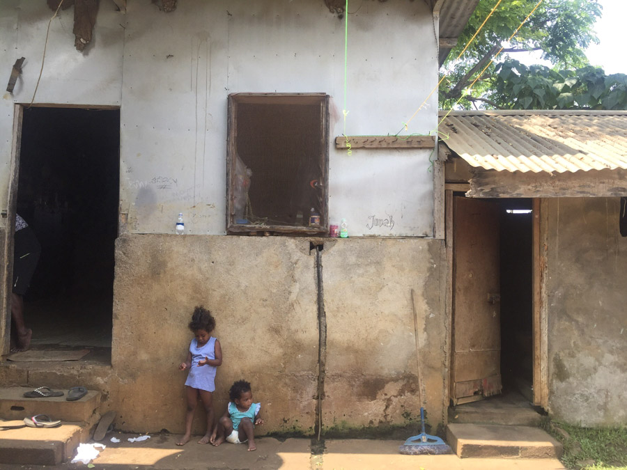 2 kids sitting outside home in Vanuatu