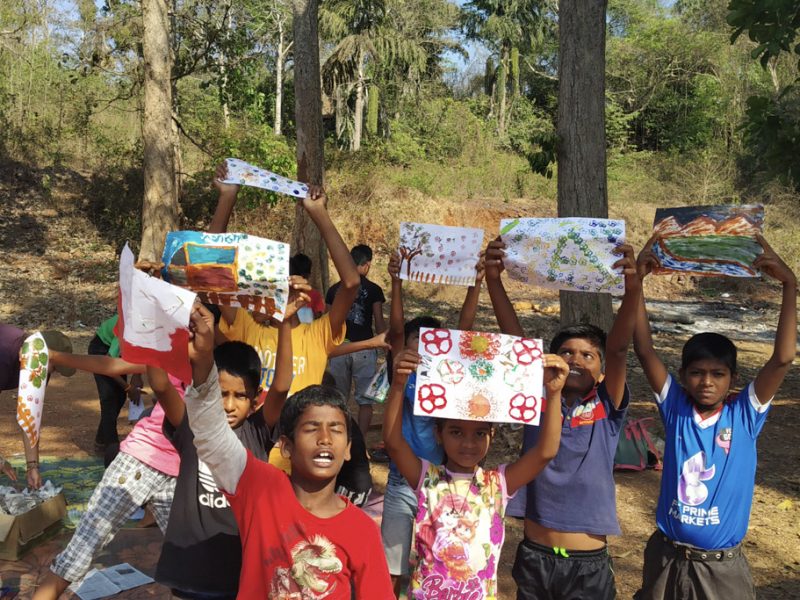 children holding up art work