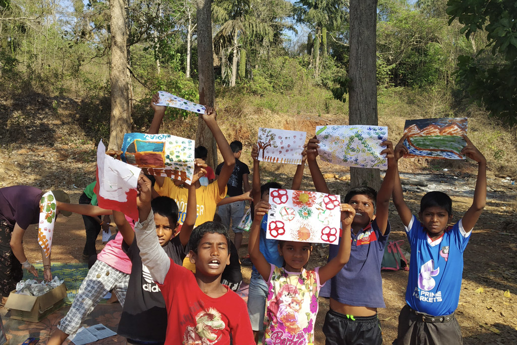 children holding up art work