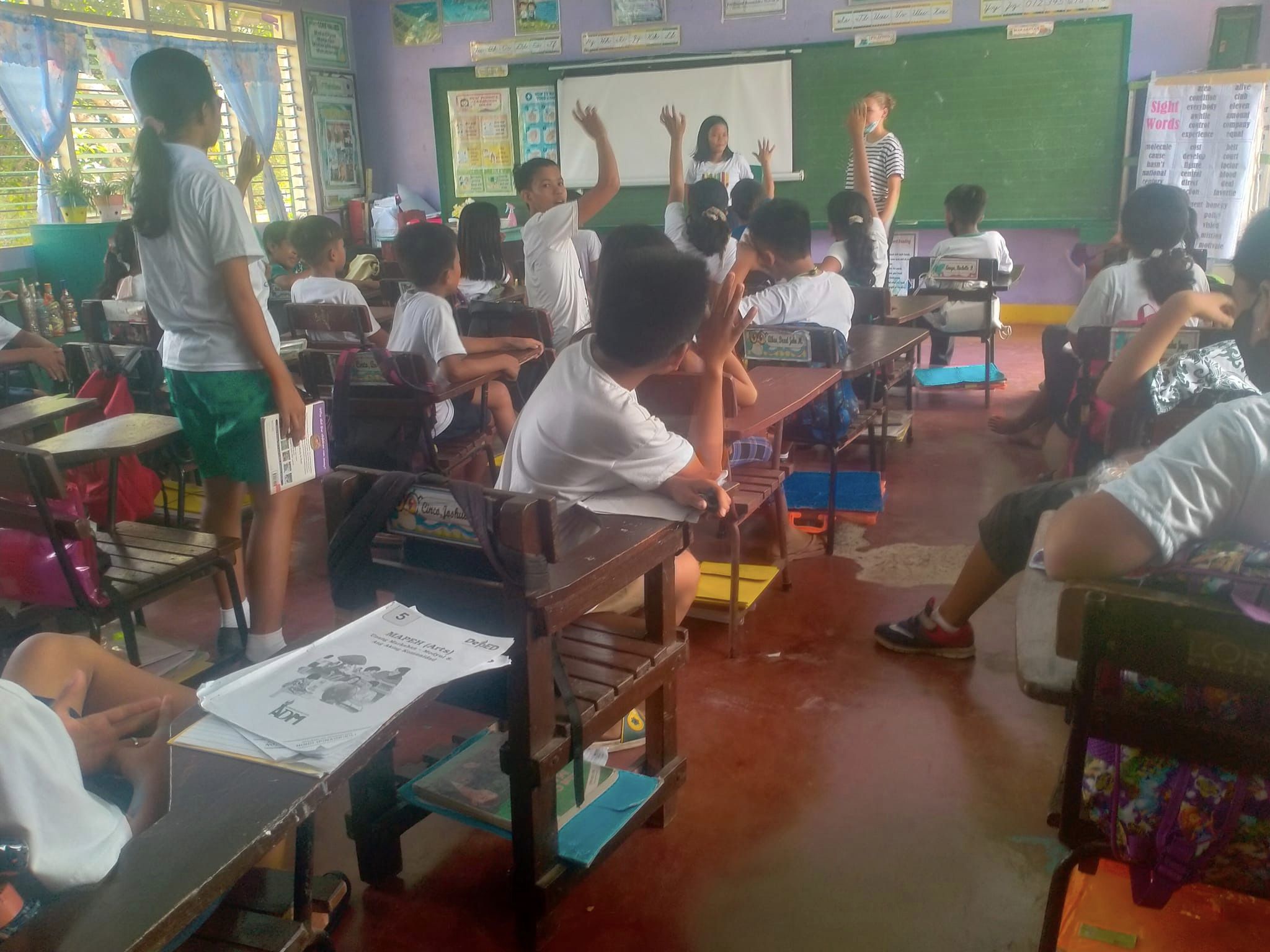 kids raising hands in class