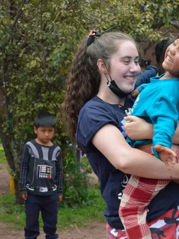 volunteer-holding-child-in-peru-4-scaled