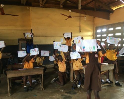 children holding up their art work