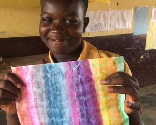 child holding up his painting