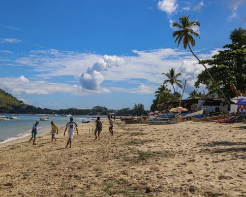 locals playing football on beach