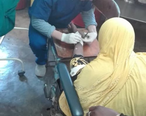 volunteer treating a wound on medical project, Tanzania