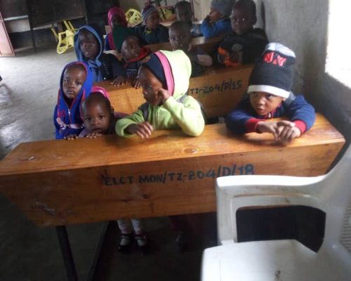 Tanzanian children sitting on school desks