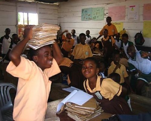 student with book pile on his head