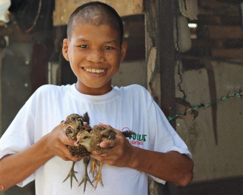 boy from shelter holding chicks-