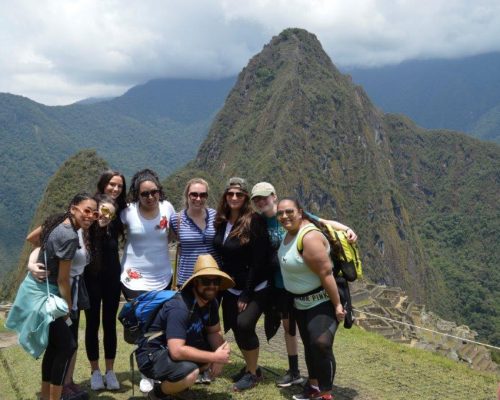 Cusco volunteers in front of machu pichu amazing scenery