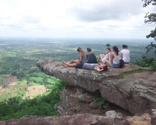 5 volunteers on the cliff looking out to distant cambodia