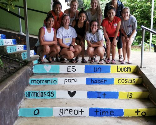 group stand by art work on steps