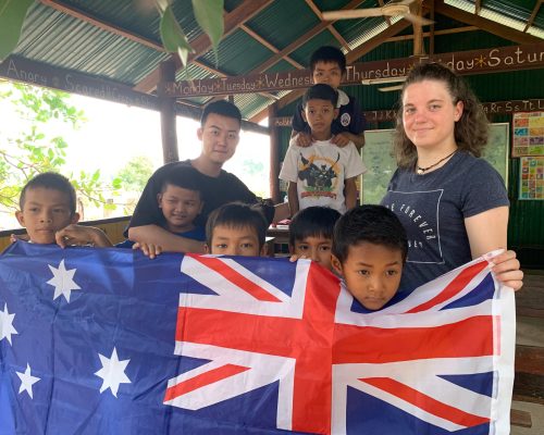 joydyn with kids in cambodia and australia flag