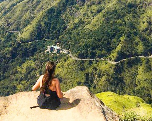 sitting on a rock overlooking green countryside